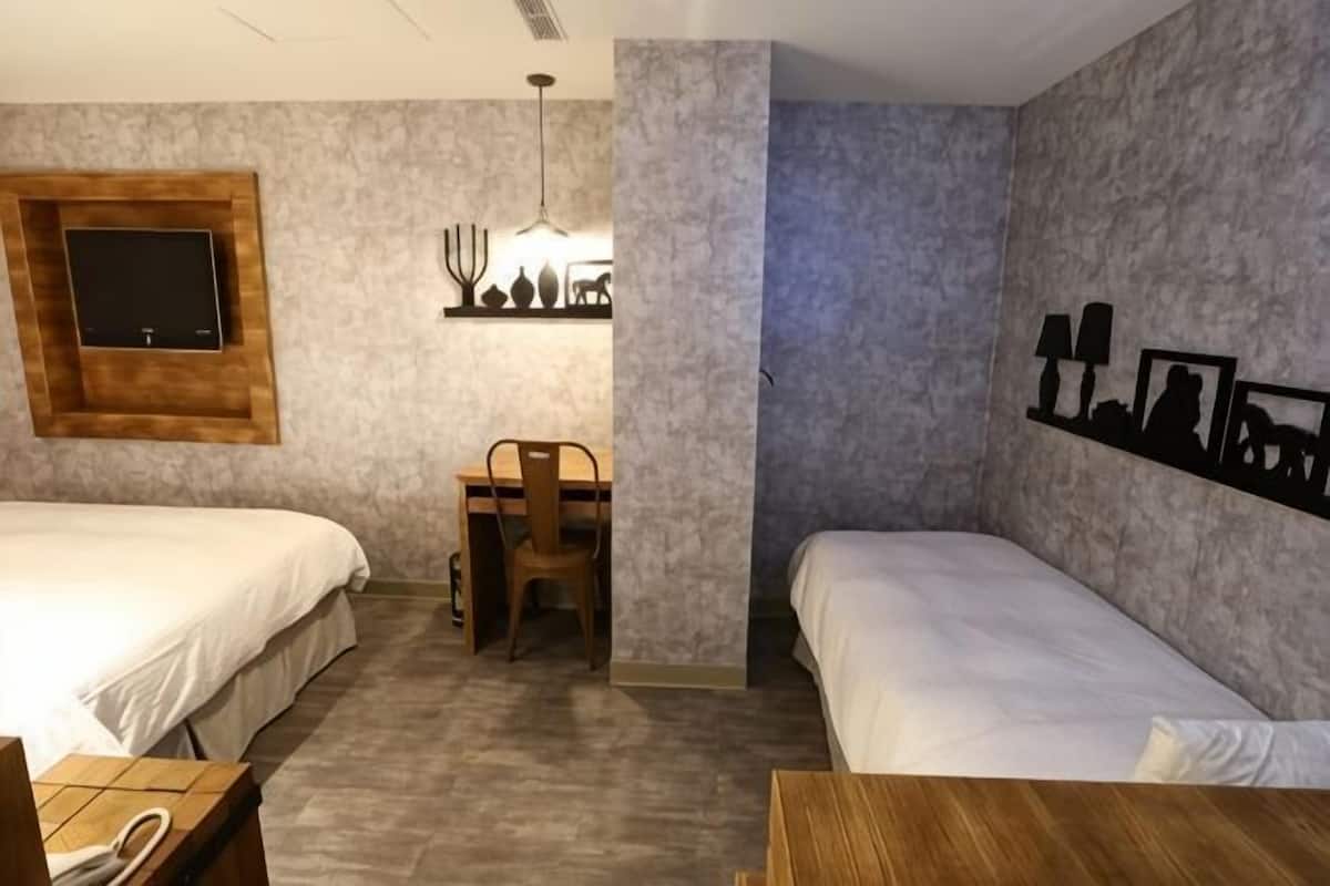 Un dormitorio con dos camas, un escritorio y una silla.