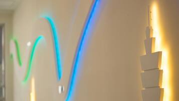 A modern interior with a wall-mounted light fixture and a series of illuminated panels.
