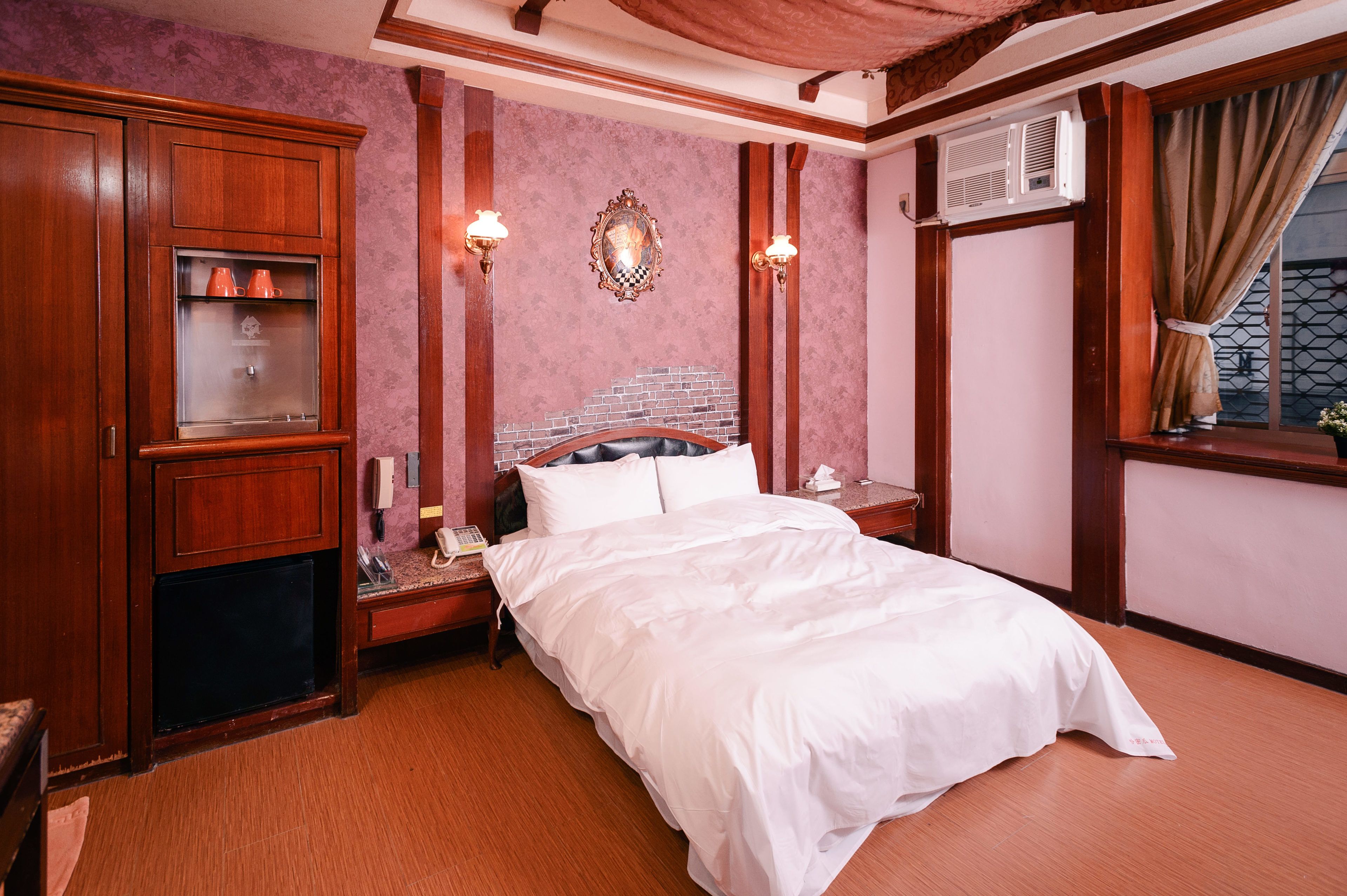 Une chambre d’hôtel avec un grand lit, une armoire en bois et une tête de lit décorée d’un motif en briques.