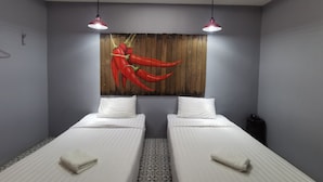 A room with two beds, a wooden wall panel with red chili peppers, and two pendant lights. - Happy Field Resort Cha-am (Cha-am)