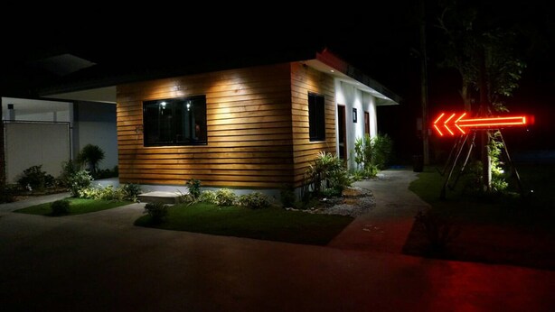 A modern house at night with a well-lit exterior and a directional sign. - Happy Field Resort Cha-am (Cha-am)