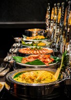 A buffet with various dishes including shrimp, rice, and other foods.