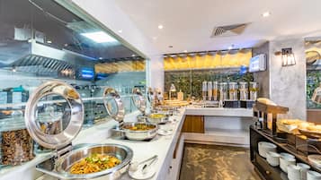 A buffet area with various food stations, including a salad bar and a hot food station.