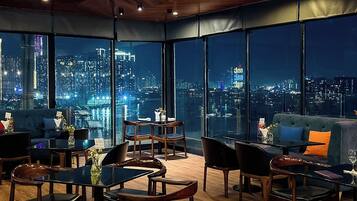 Un interior moderno con vista a la ciudad, que incluye un sofá, una mesa de comedor y sillas.