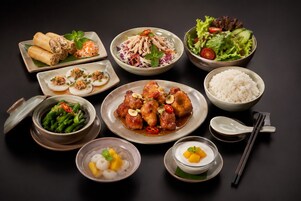 A variety of dishes including spring rolls, a salad, and a bowl of rice.