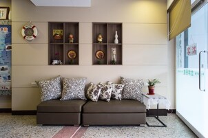 A living room with a sofa, decorative shelves, and a small table with a plant.
