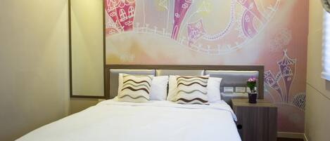 Una habitación de hotel con una cama grande, una mesita de noche y un mural en la pared.