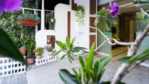 A modern building with a signboard, potted plants, and a glass entrance. - Bei Pin B&B (Hengchun)