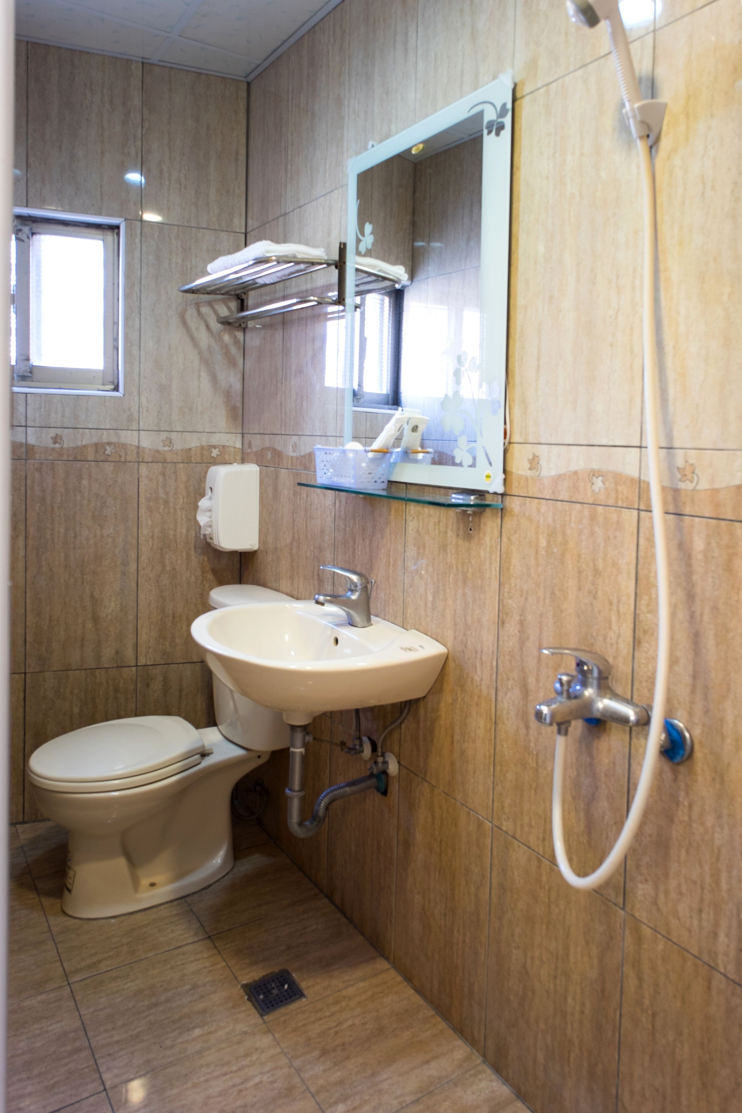 A bathroom with a toilet, sink, and shower.