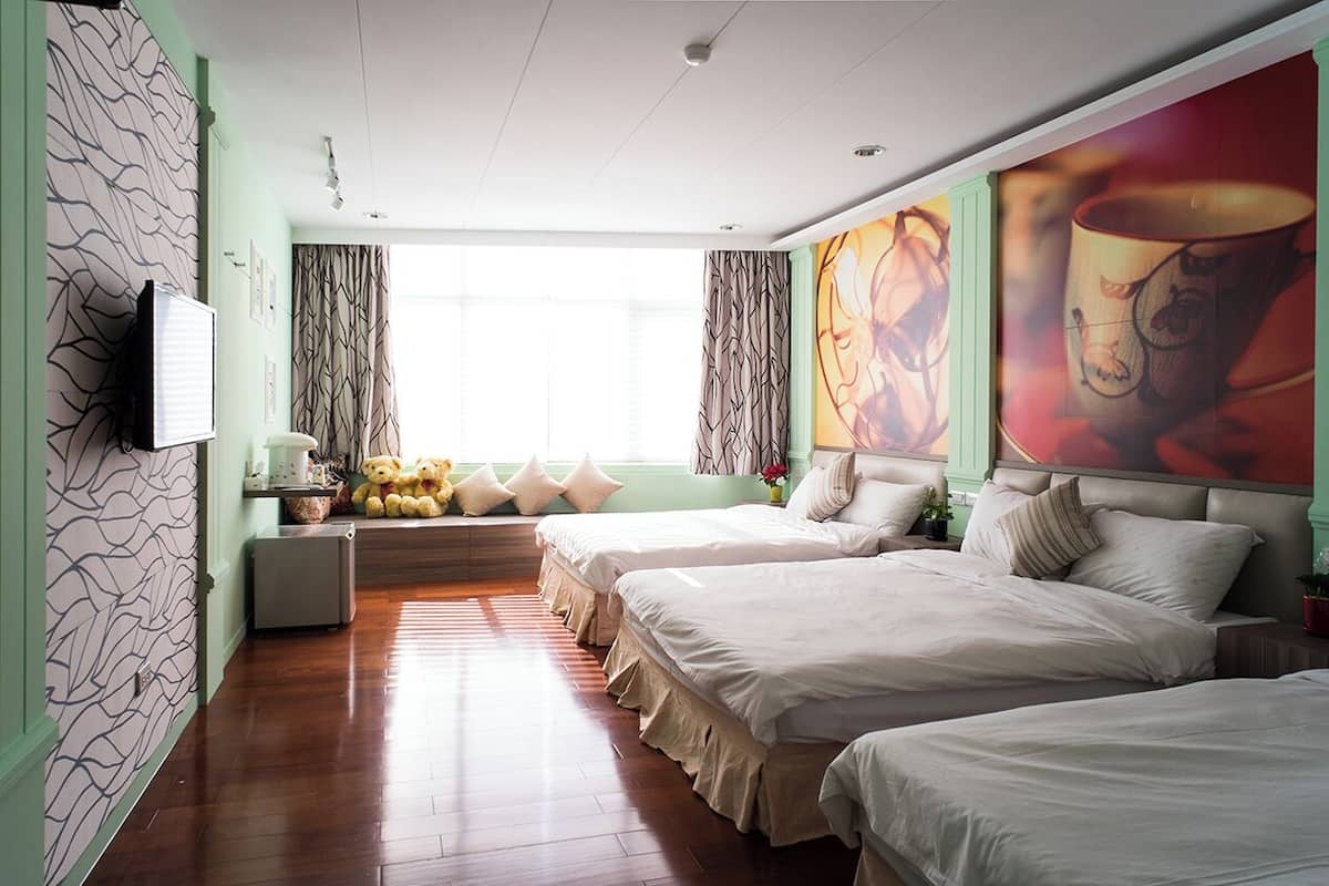 Quarto de hotel com duas camas, televisão, janela com cortinas e parede com uma pintura grande.