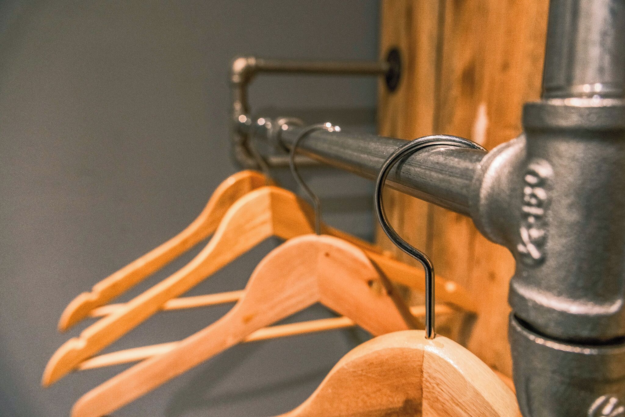 Un gancho metálico con perchas de madera.