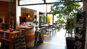 A restaurant interior with a wine tasting setup, including a chalkboard menu, wine glasses, and bottles. - Hôtel L'Hotan (Portet-sur-Garonne)