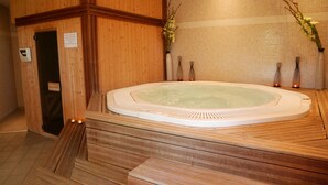 A wooden spa area with a hot tub, wooden steps, and tiled walls. - Hôtel L'Hotan (Portet-sur-Garonne)