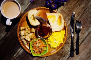 A breakfast plate with toast, scrambled eggs, potatoes, and a small bowl of vegetables. - The Leaf Inn (Hualien City)