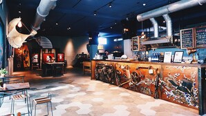 A restaurant interior with a bar area, hexagonal patterned floor, and various artworks on the walls. - The Leaf Inn (Hualien City)