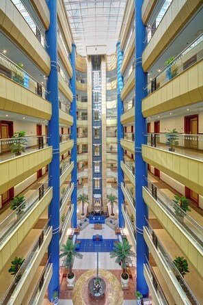 A multi-level hotel atrium with a central open space, multiple floors, and a modern design. - Al Manar Grand Hotel Apartments (Dubai)