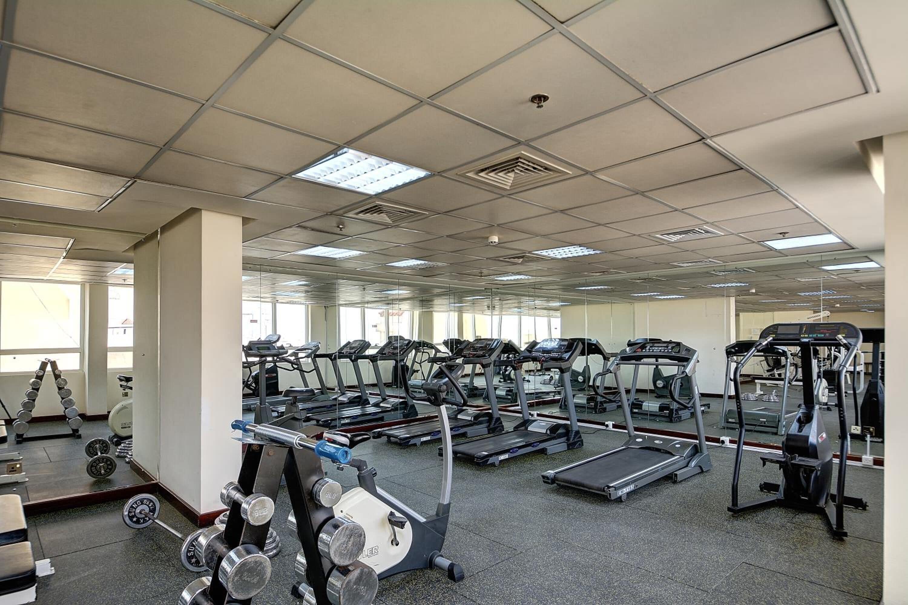 A gym with multiple treadmills, weight machines, and free weights.