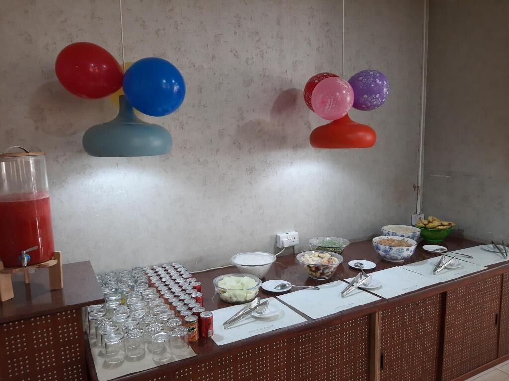 A buffet setup with various food items and a beverage dispenser.