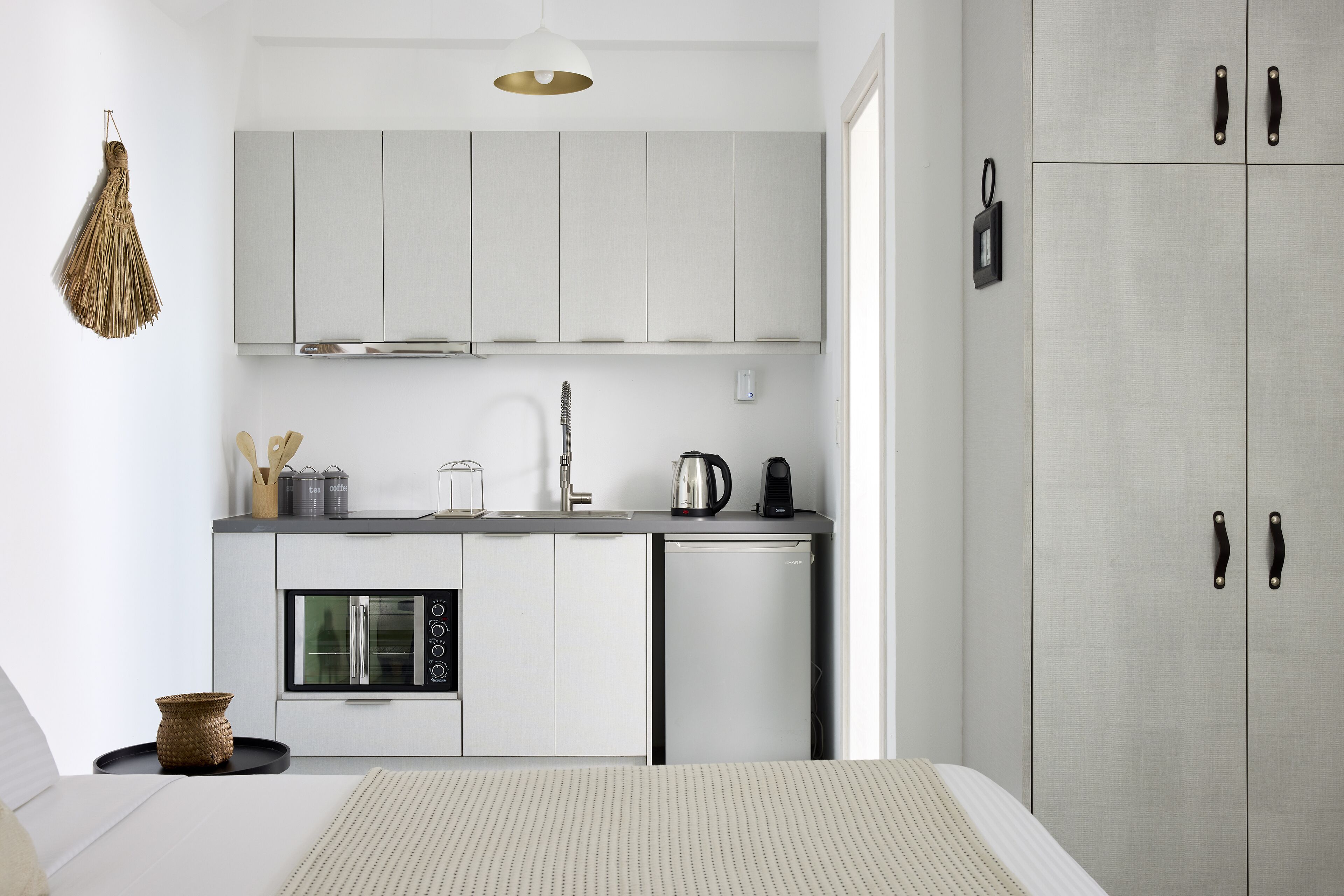 A compact kitchen with a built-in oven, a coffee maker, and a dishwasher.