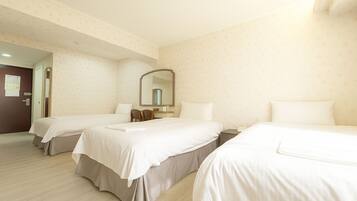 A hotel room with two beds, a desk, a chair, a mirror, and a door.