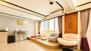 Una sala de estar moderna con un sofá, una mesita, una silla y un escritorio.