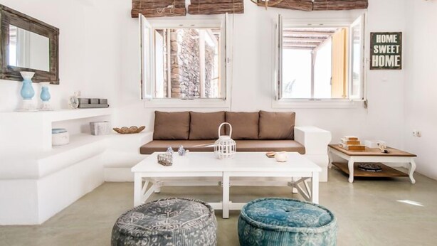 Ein modernes Wohnzimmer mit einem weißen Sofa, einem Couchtisch und zwei Hocker.
