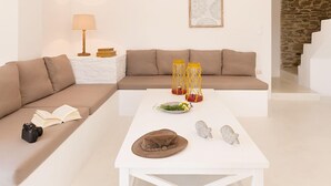 Ein modernes Wohnzimmer mit einem beigen Sofa, einem weißen Couchtisch und einer Lampe.