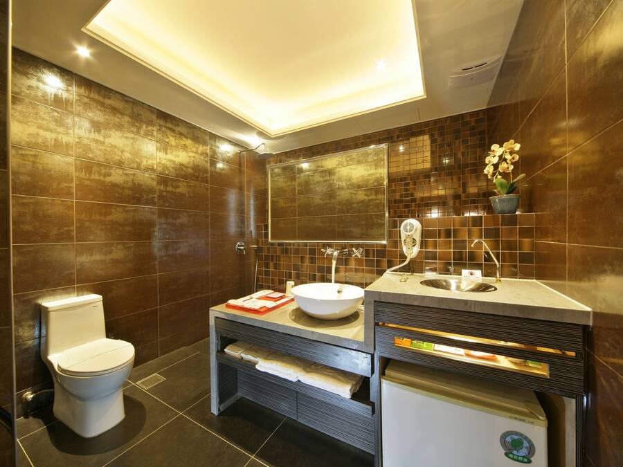A modern bathroom with a toilet, sink, and vanity.