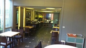 Ein Restaurant mit einer langen Theke, mehreren Tischen und Stühlen.