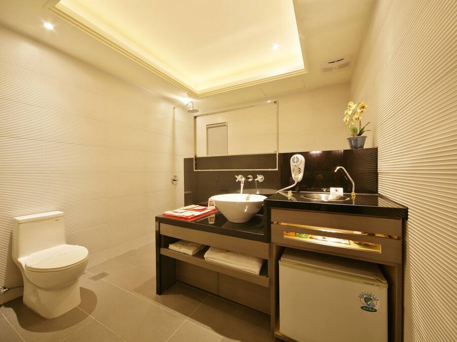 Un baño moderno con inodoro, lavabo y espejo.