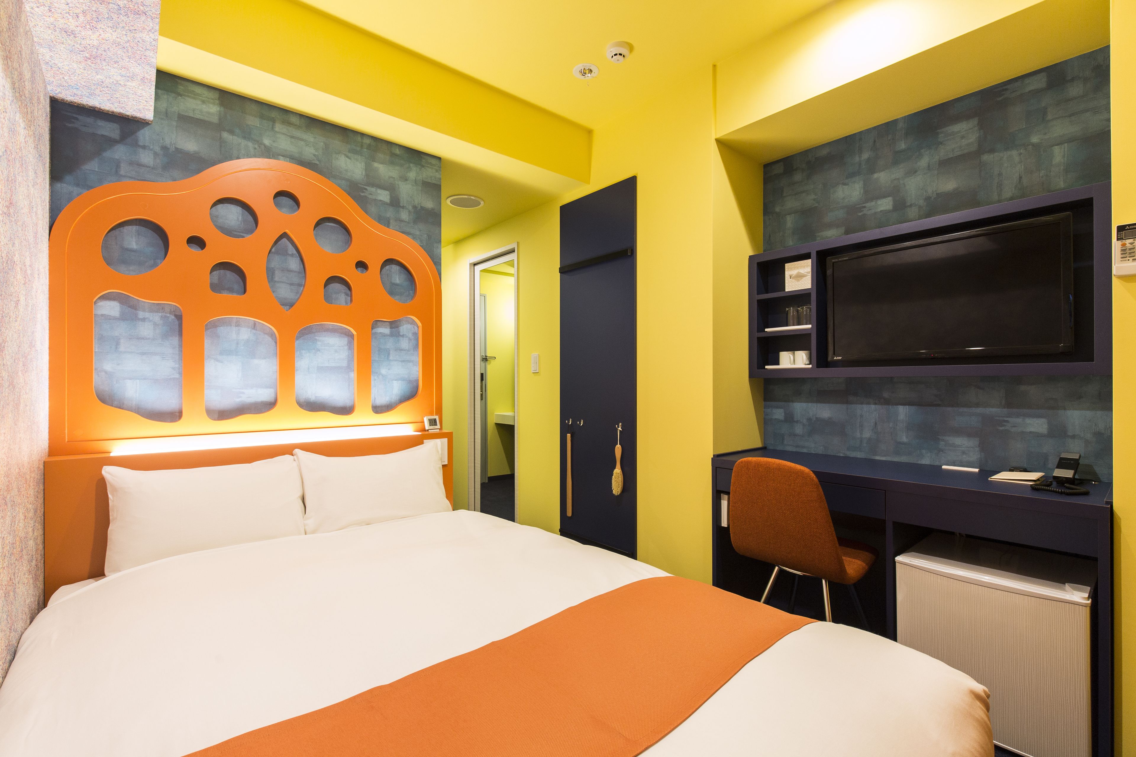 Una habitación de hotel con una cama grande, un escritorio con computadora y un televisor.