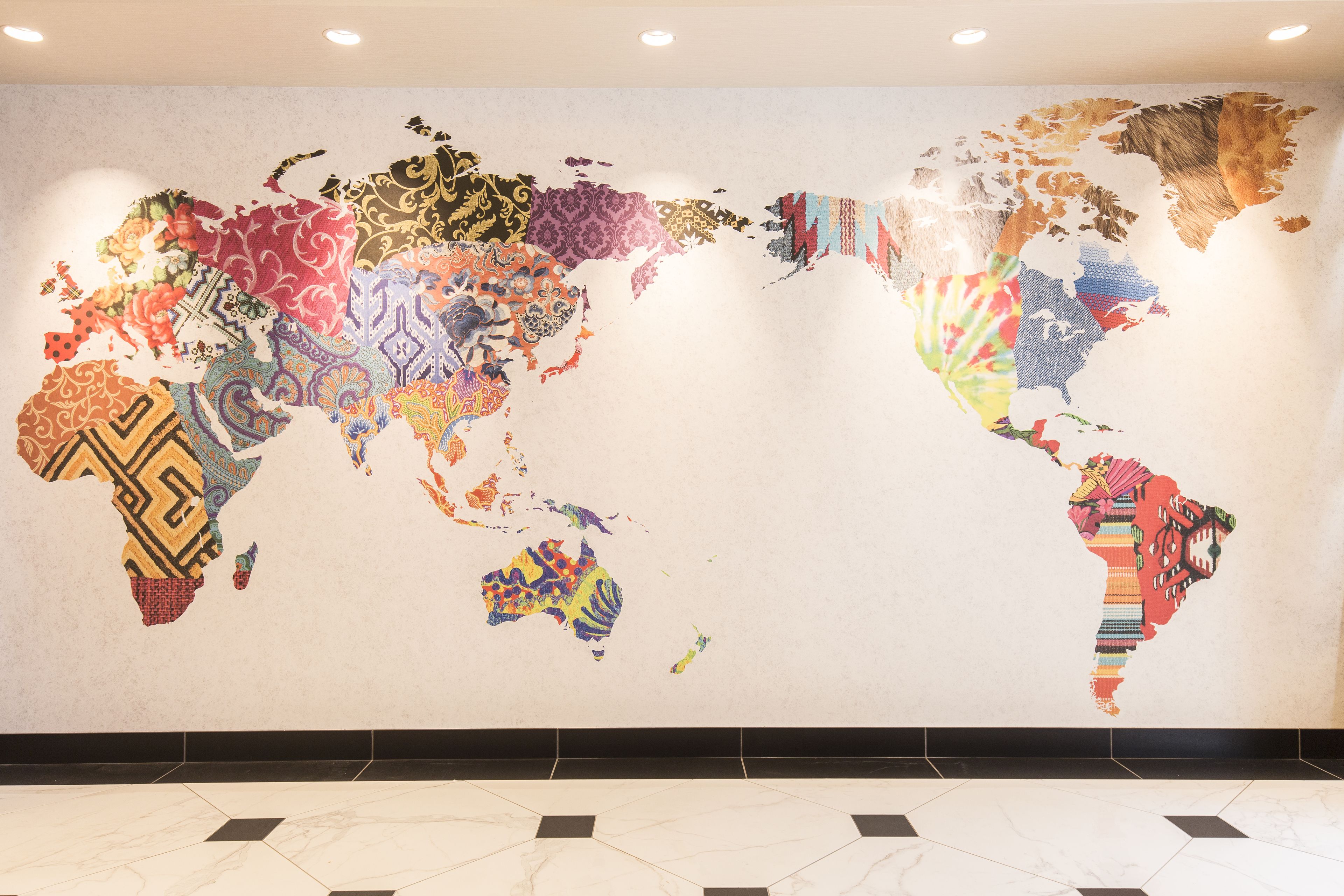A world map mural with various patterns and designs on a wall.
