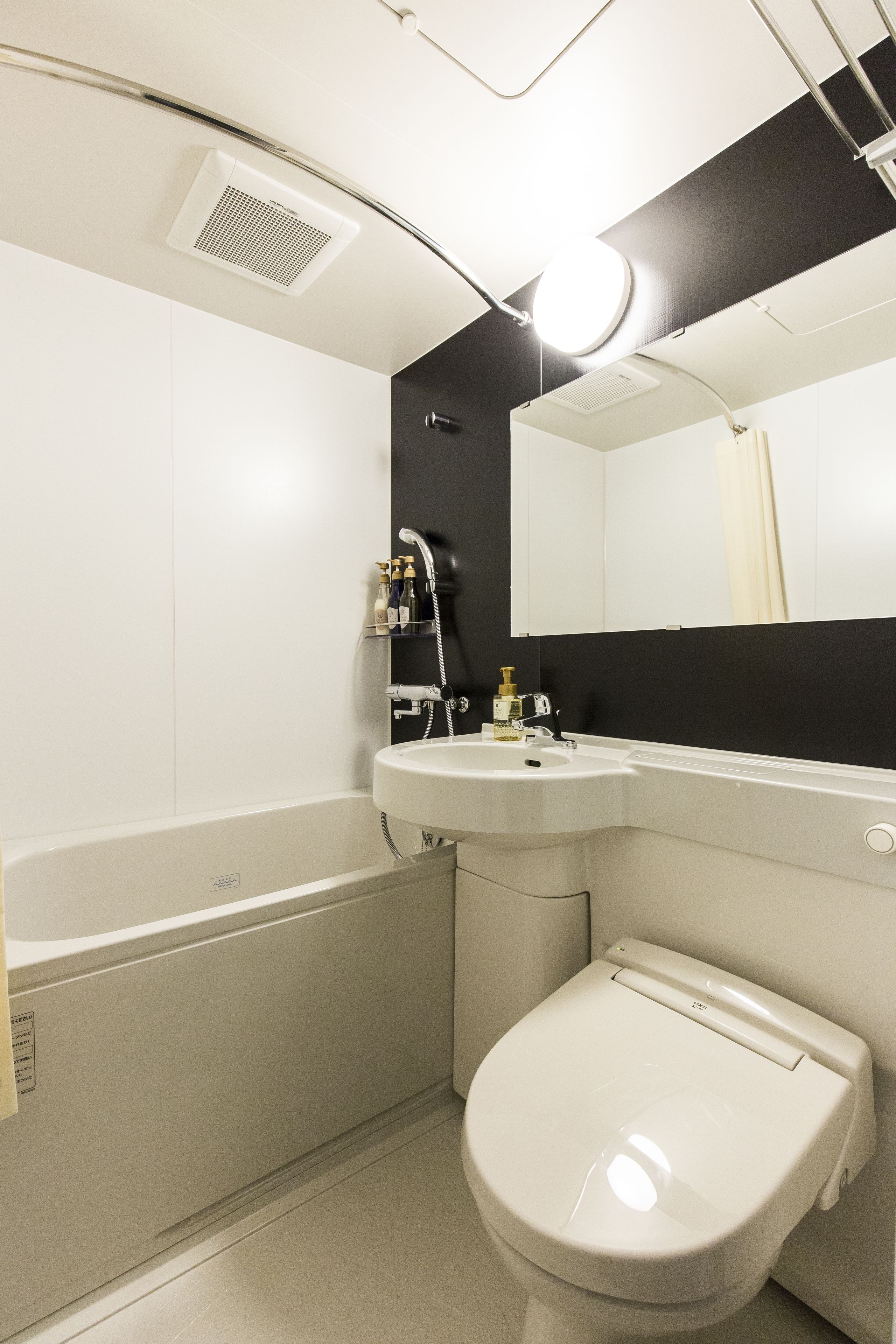Ein modernes Badezimmer mit einer weißen Badewanne, einem Waschbecken und einer Toilette.