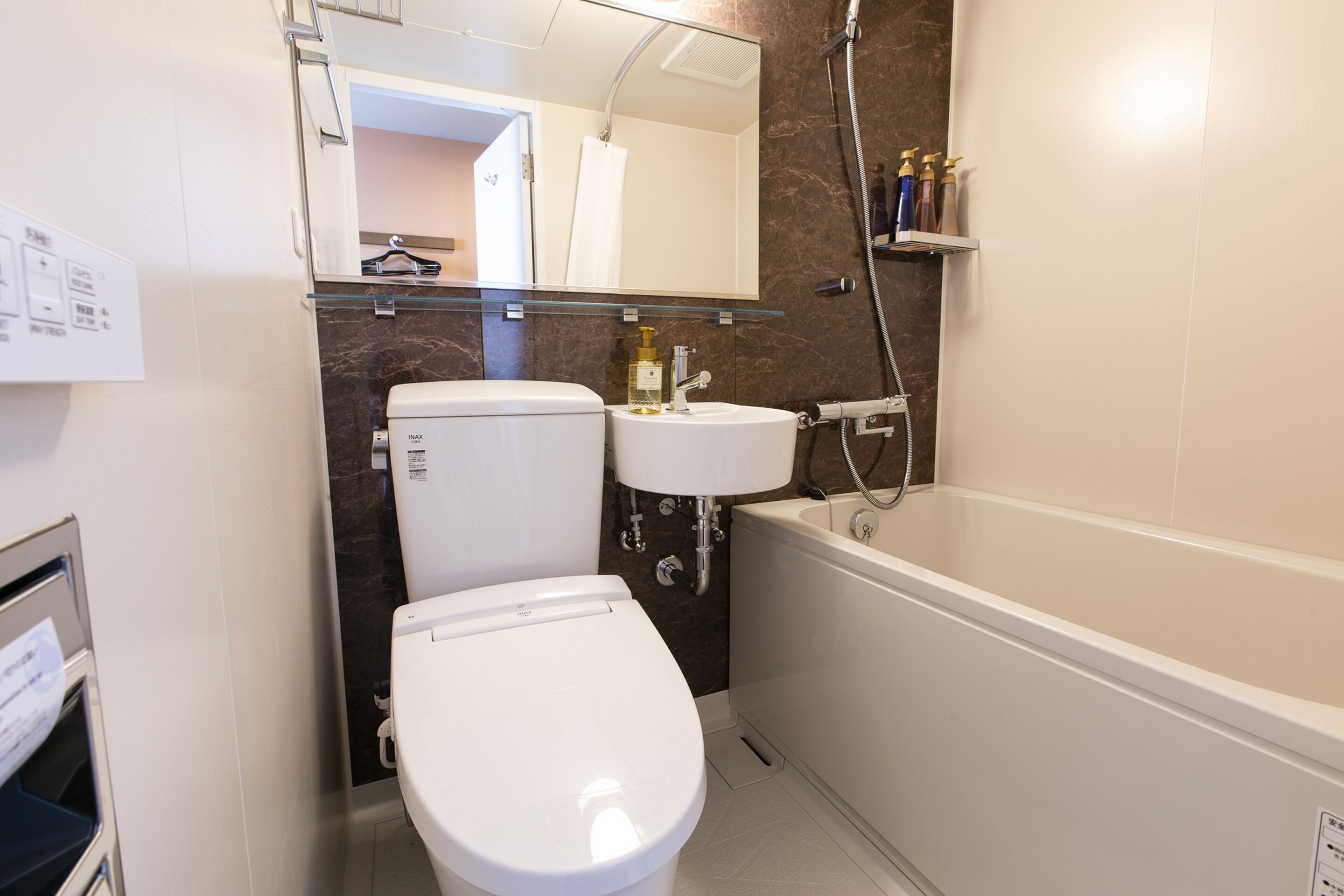 A modern bathroom with a toilet, sink, and bathtub.