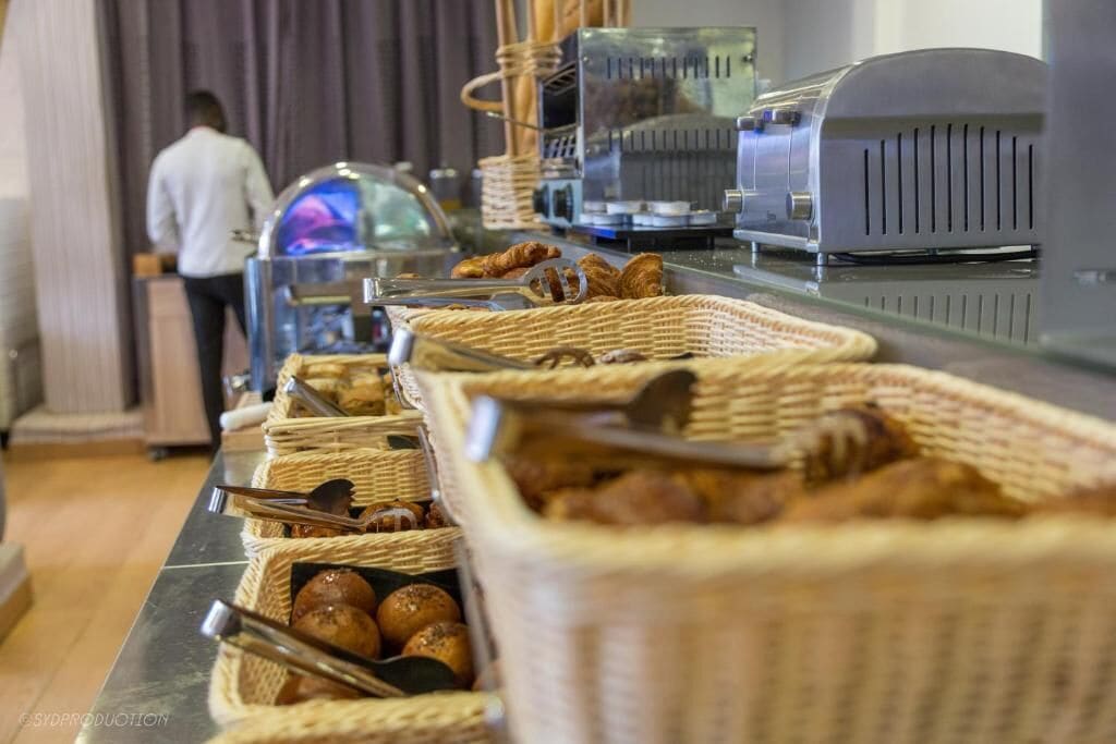 A buffet area with wicker baskets containing various baked goods and utensils.