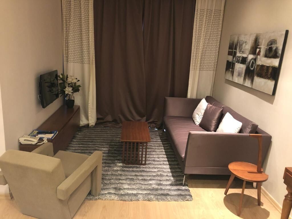 Un salon avec un canapé, un fauteuil et une petite table en bois.