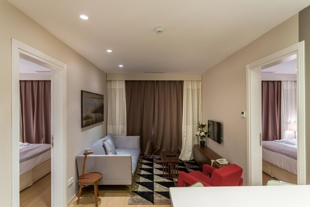 Une chambre d’hôtel avec un lit, un canapé, un bureau et une chaise.