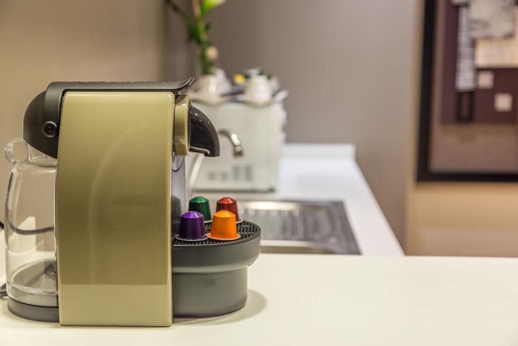A coffee machine with a transparent water reservoir and a control panel.