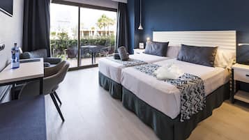 Een hotelkamer met een bed, een bureau, een stoel en uitzicht op het omliggende landschap.