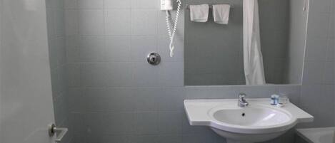 Un baño con inodoro, lavamanos y zona de ducha.