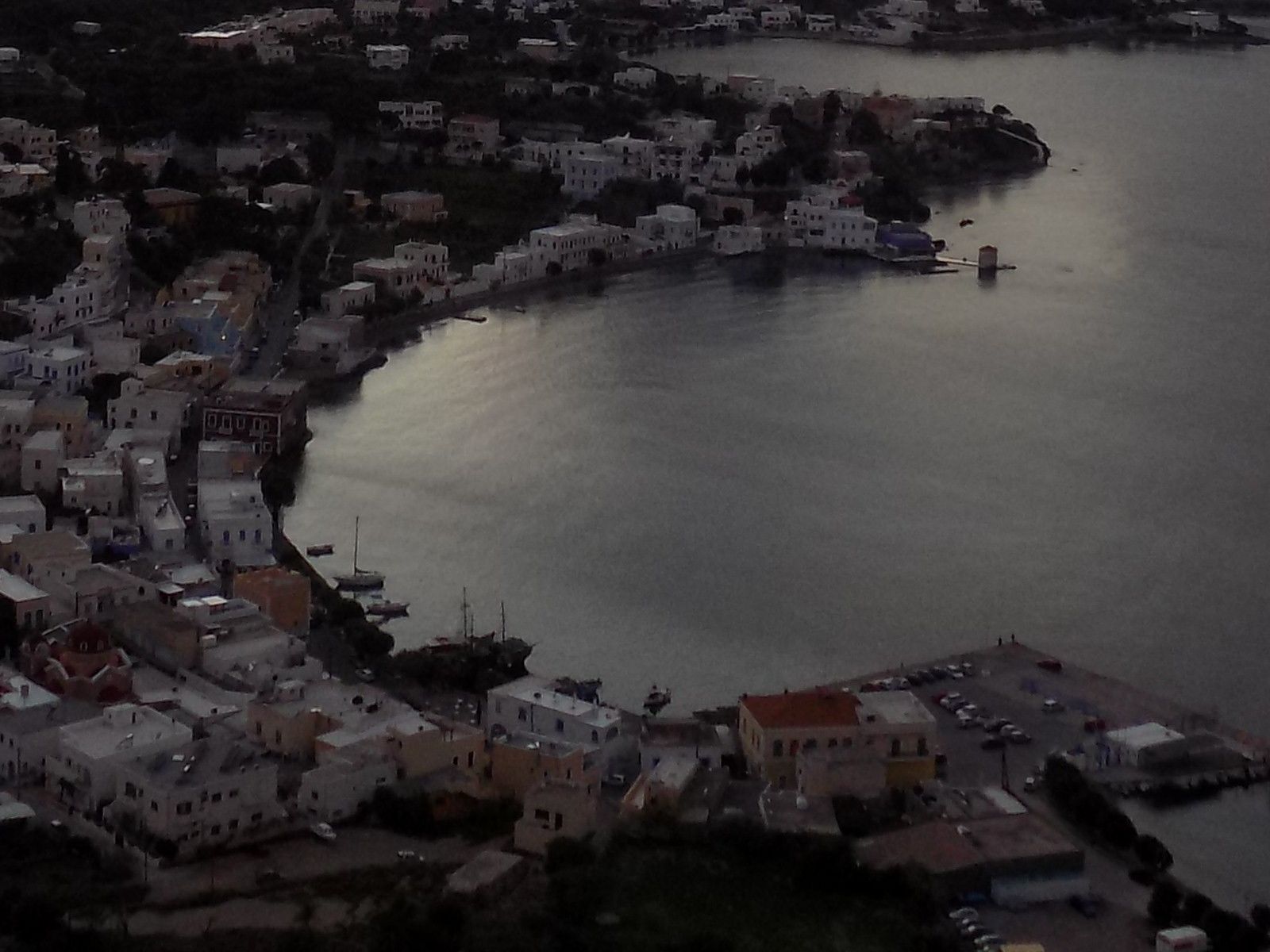 Une ville côtière avec des bâtiments le long du front de mer, un port de plaisance et un petit quai.
