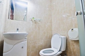 Un baño con inodoro, lavabo y espejo.