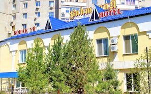 Un hotel con techo azul y ventanas arqueadas.