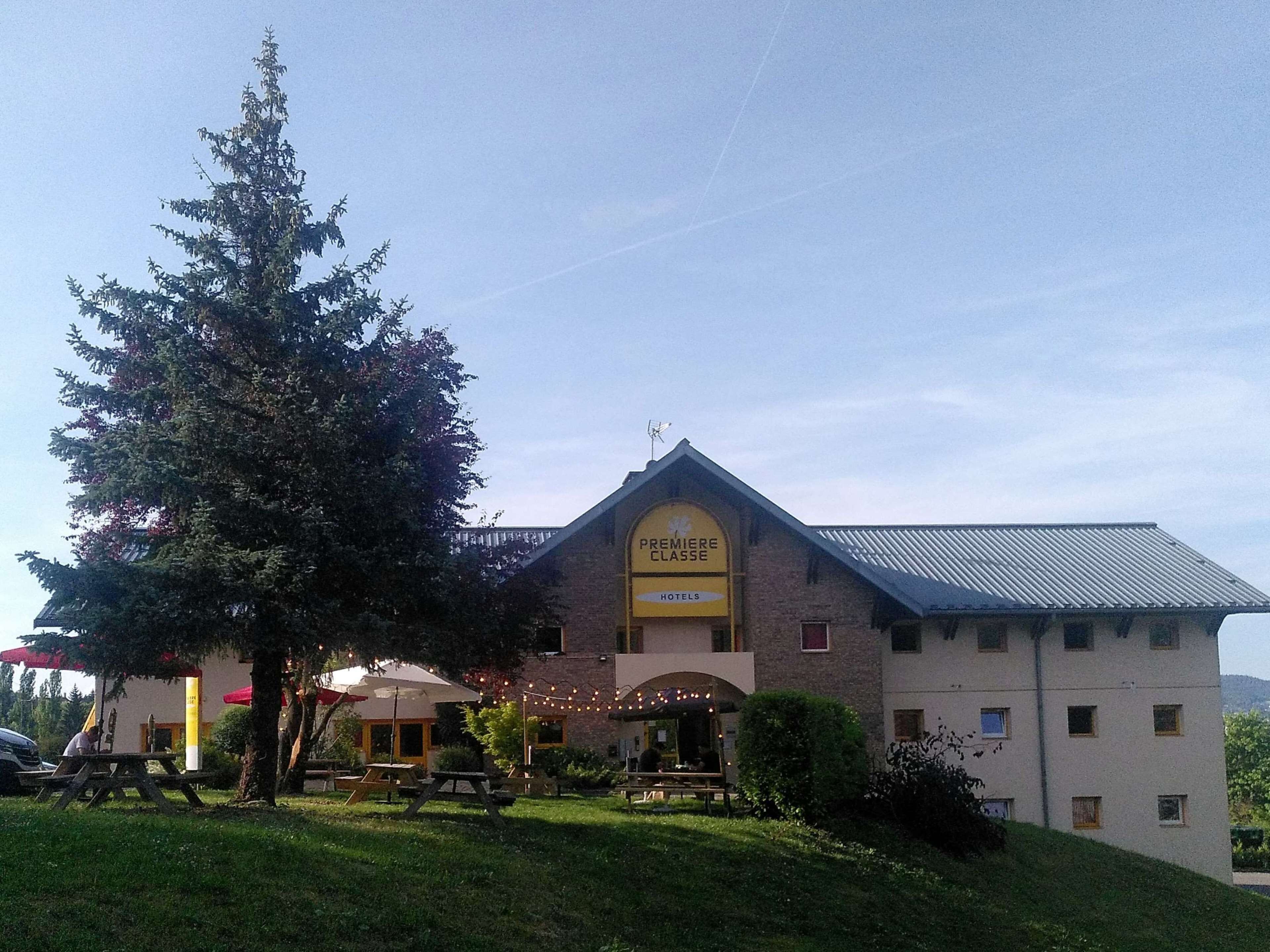 A hotel with a prominent sign reading "PREMIERE CLASSE HOTELS" and a brick facade.