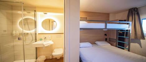 Habitación de hotel compacta con ducha, inodoro y una cama litera.