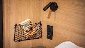 A wooden wall with a black speaker and a black door handle.