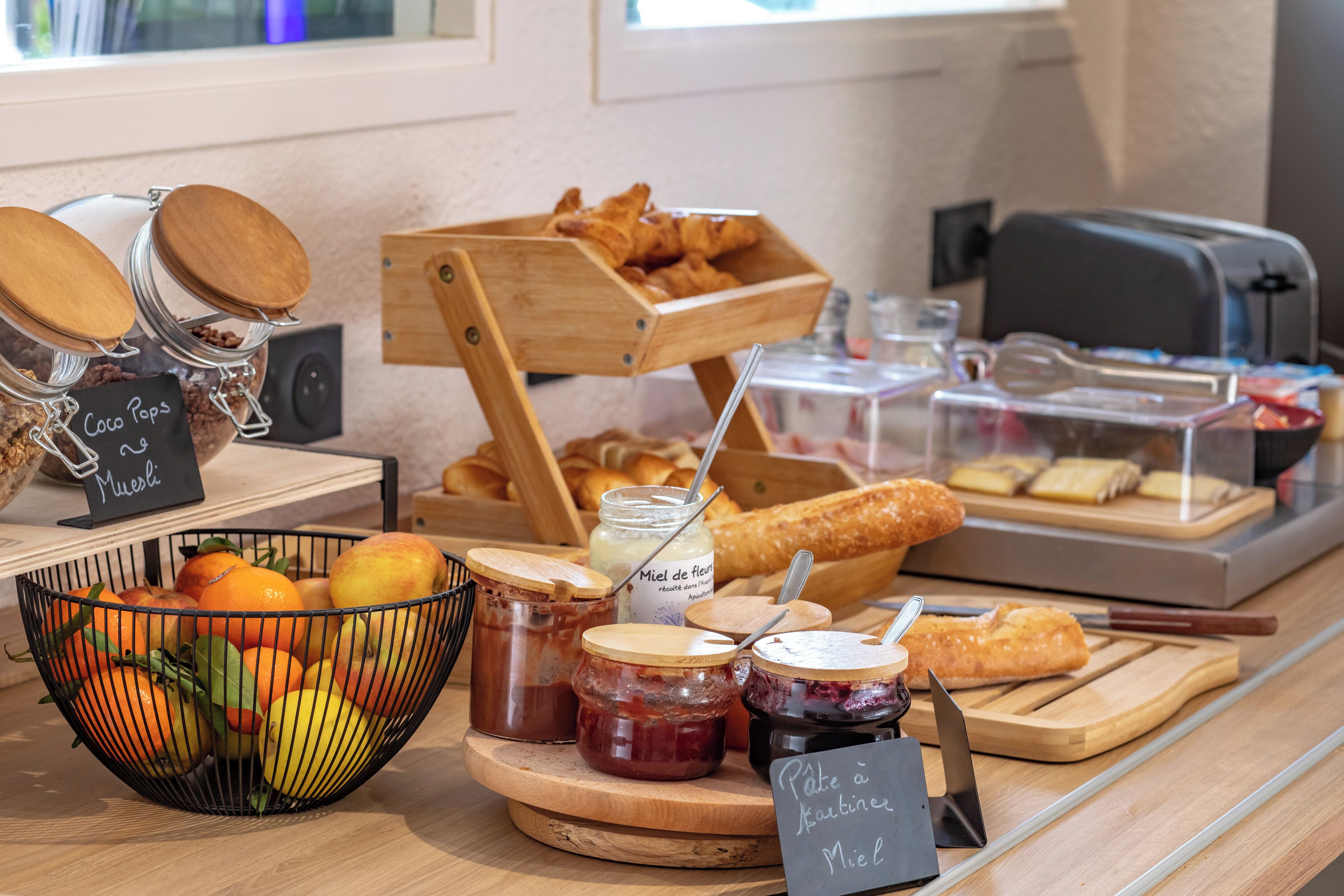 Een ontbijtbuffet met diverse soorten eten, zoals fruit, gebak en toevoegingen.