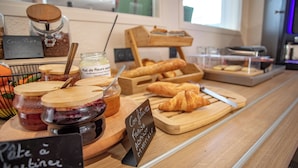 A bakery counter with various pastries, jars of jam, and a sign indicating a pastry menu.