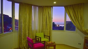 A corner room with two windows, a table with fruit, and two chairs. - Hotel Marina Prestige Tabarka (Tabarka)
