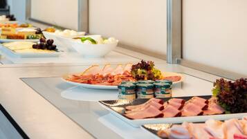 A buffet with various food items including meats, cheeses, and salads.